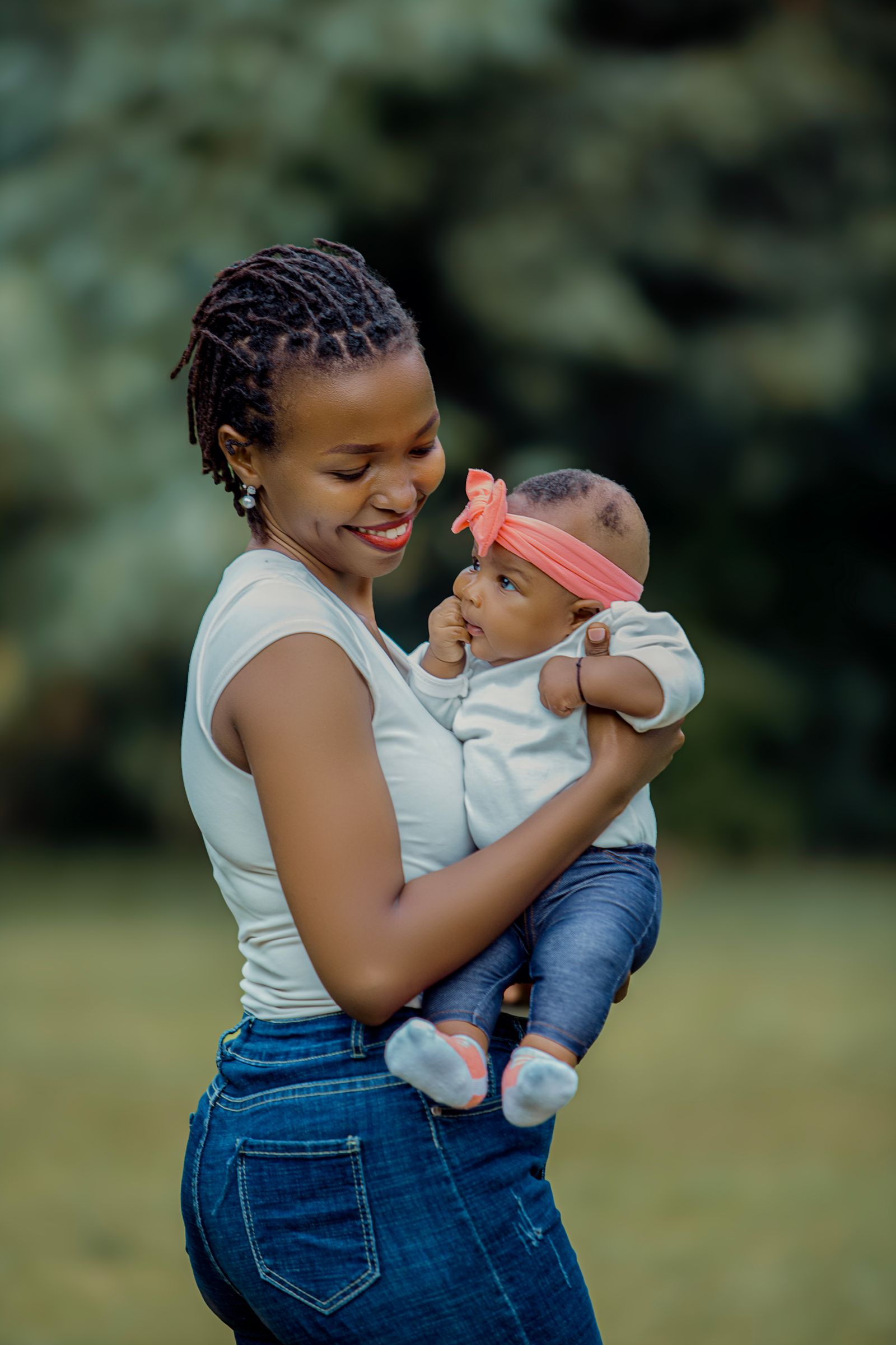 A mother holding her baby outdoors
